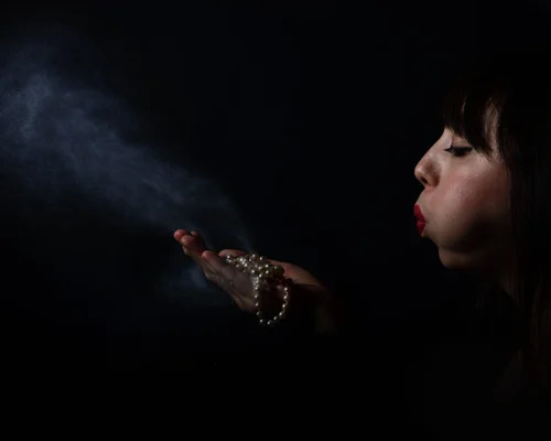 Woman blowing dust from jewellery